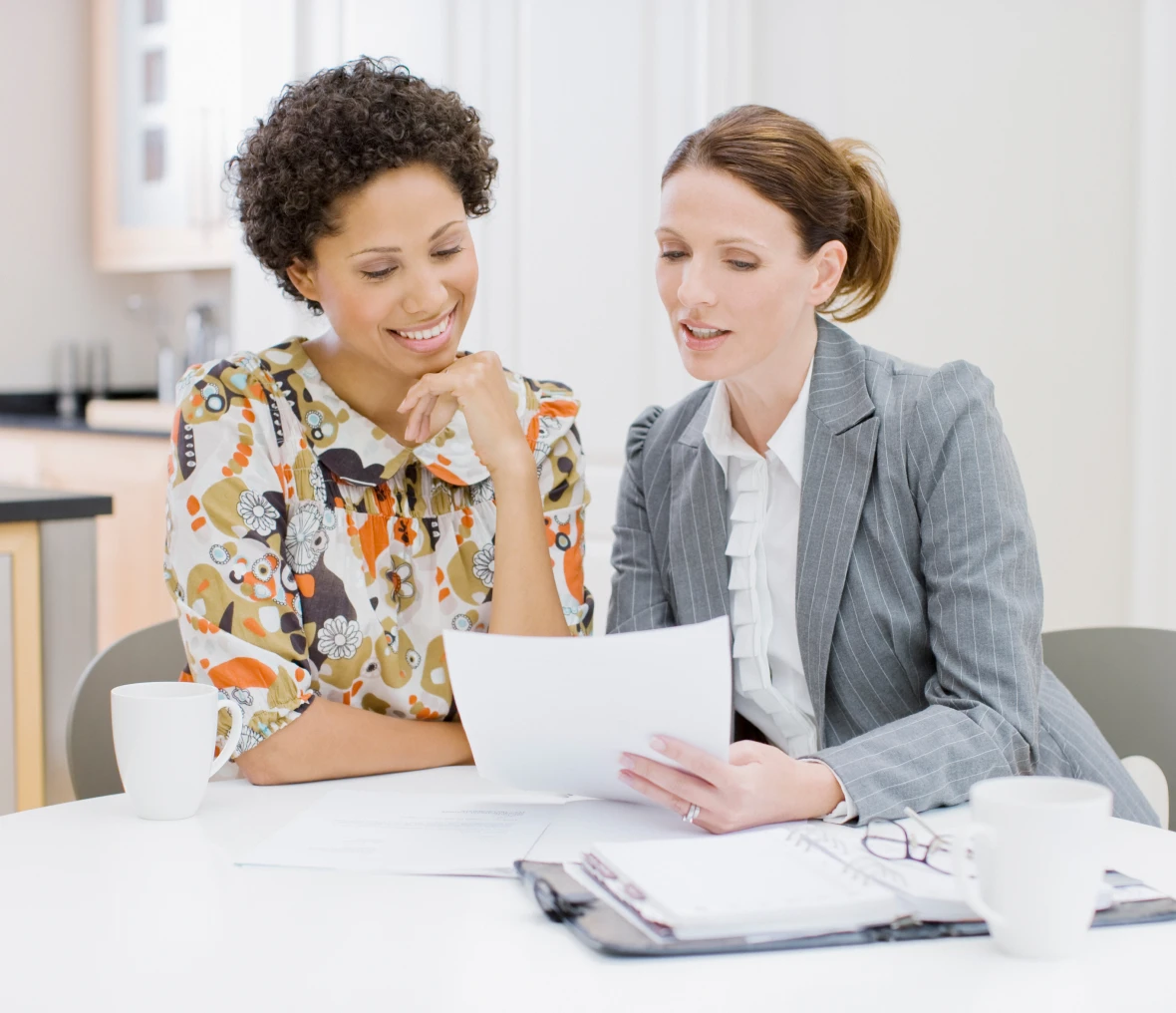 Two women reviewing documents at table